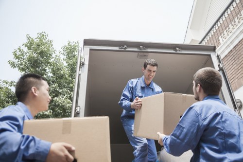 Local moving truck loading household furniture in Queens Park